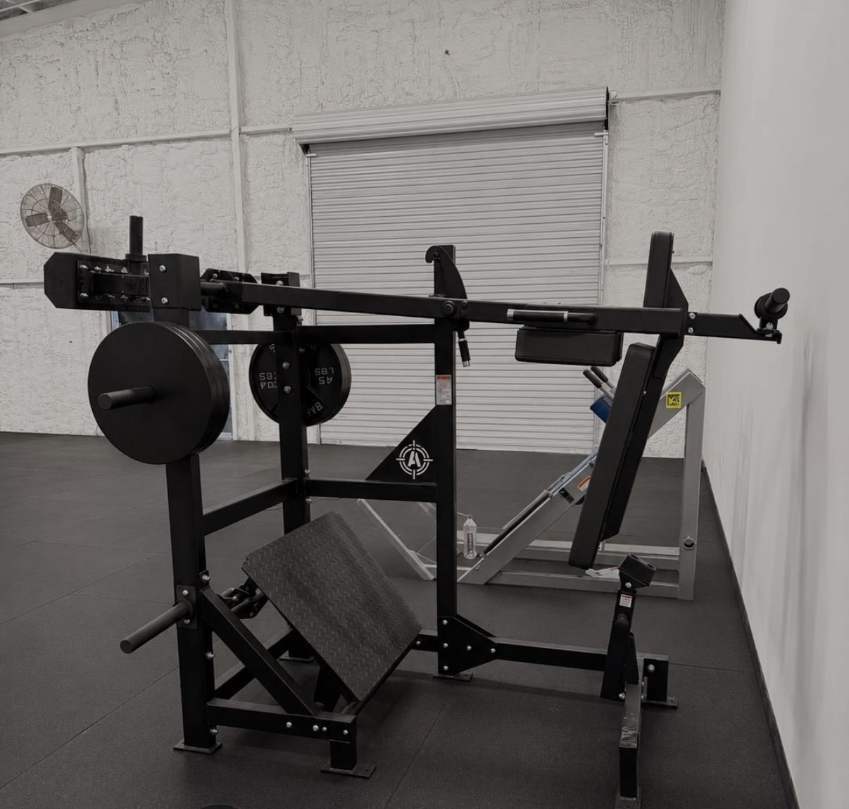 Gym floor at Grail Gym San Antonio with plate-loaded squat and hack squat machines